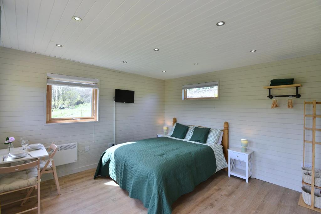 um quarto com uma cama, uma secretária e uma janela em Anniston Mill Cabin 1 em Arbroath