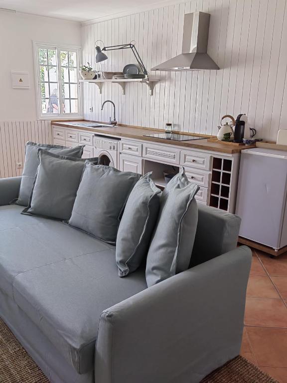 a living room with a gray couch with pillows at Casinha do Chico in Charneca
