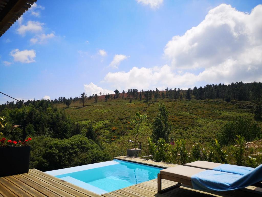 a swimming pool with a view of a hill at Em Xisto - Casas de Montanha - Casa T0 in Góis