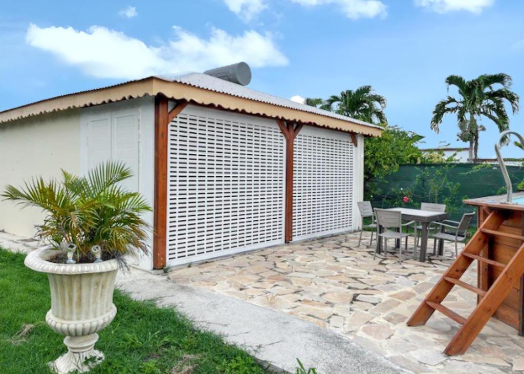 ein Gebäude mit Jalousien auf einer Terrasse in der Unterkunft Maison d'une chambre avec piscine privee jardin clos et wifi a Port Louis in Port-Louis