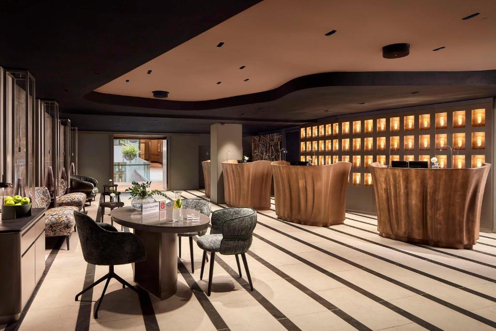 a lobby with a table and chairs and a bar at NH Collection Helsinki Grand Hansa in Helsinki