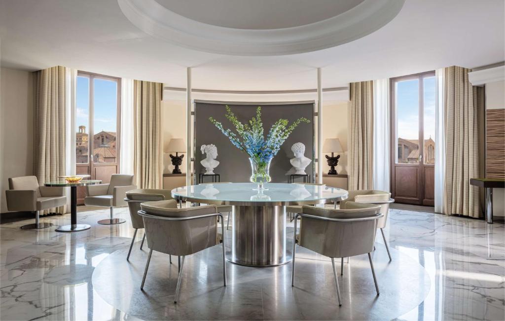 ein Esszimmer mit einem Tisch und einer Vase aus Blumen in der Unterkunft Anantara Palazzo Naiadi Rome Hotel - A Leading Hotel of the World in Rom