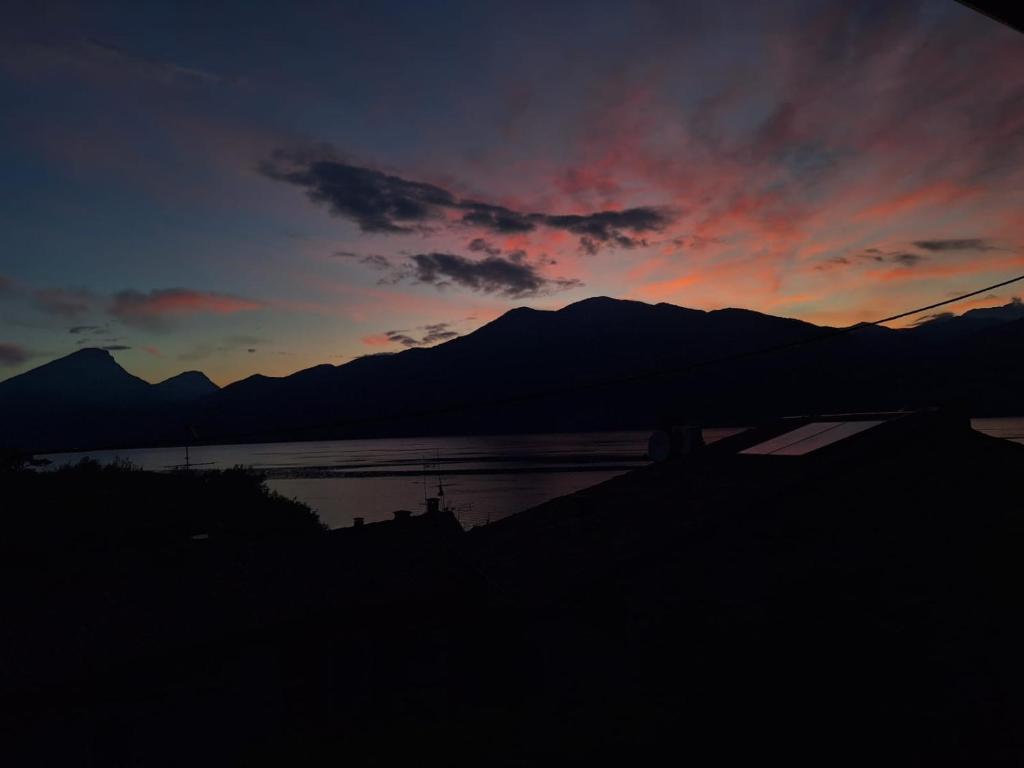 a sunset over a body of water with mountains at Appartamento con vista Lago Casa Gaspar in Brenzone sul Garda