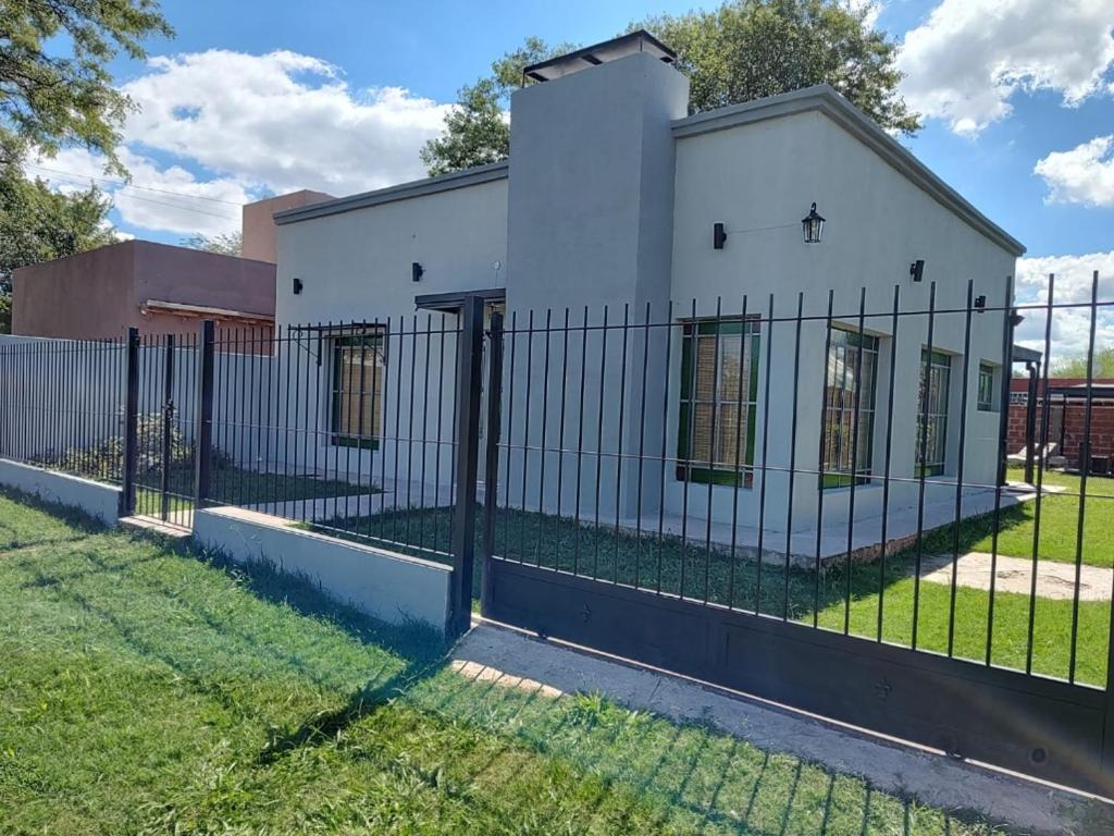 a fence in front of a white house at Los Abuelos in Duggan