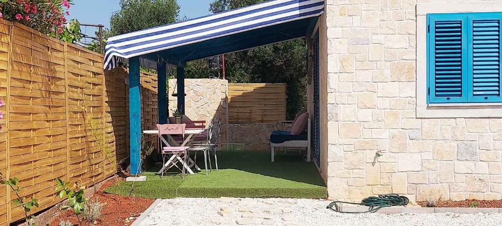 un patio avec un auvent bleu et blanc et une chaise dans l'établissement Holiday home in Ugljan - Insel Ugljan 50384, à Ugljan