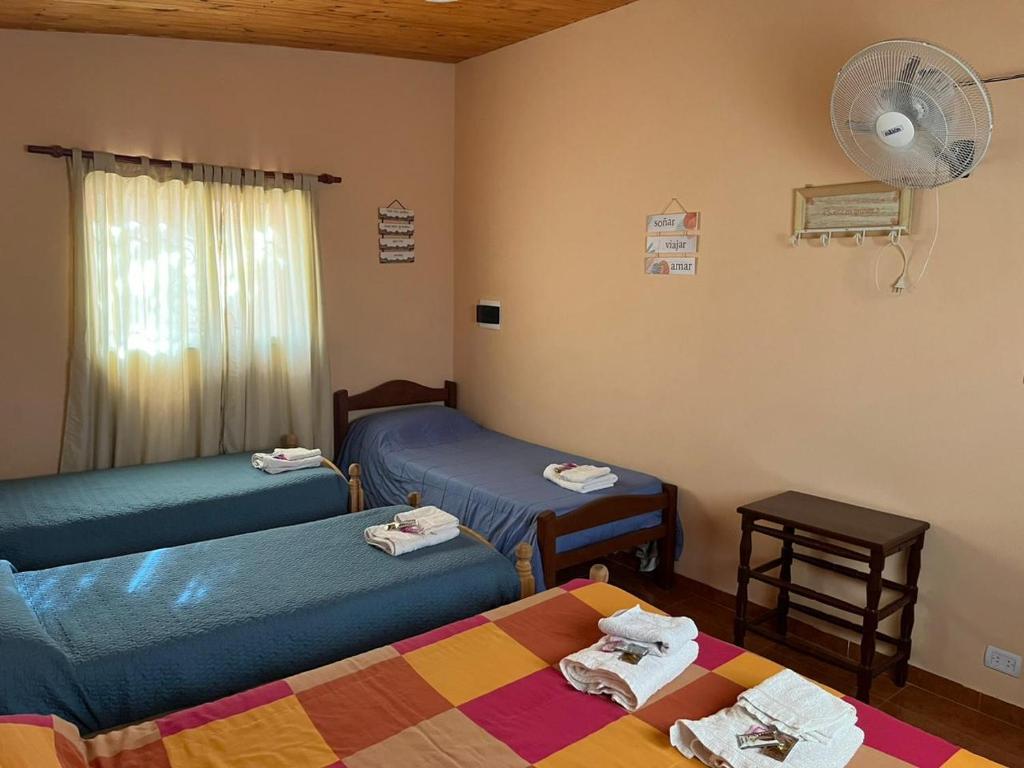 a room with two beds and a fan at Descanso el abuelo in Londres