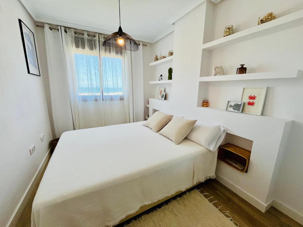 a white bedroom with a large bed with white shelves at Mirador mar-BookApartments in Peñíscola