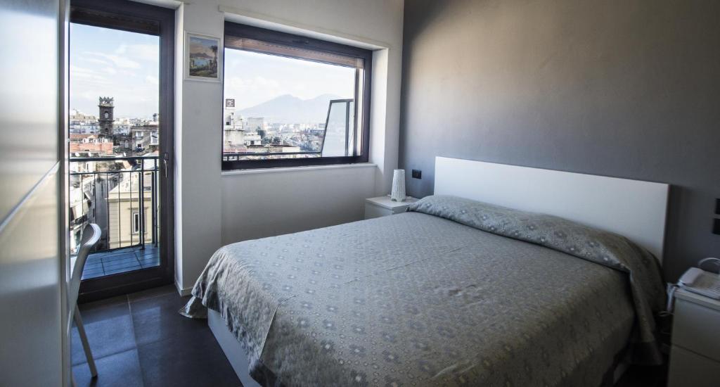ナポリにあるB&B ロカンダ メディテラニアのベッドルーム1室(ベッド1台、大きな窓付)