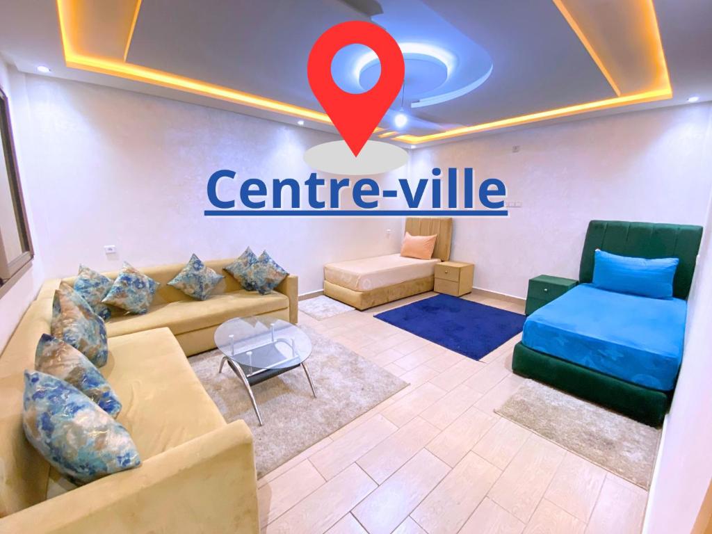 ein Wohnzimmer mit einer Couch und einem roten Marker in der Unterkunft Élégant appartement au cœur du Laâyoune in El Aaiún