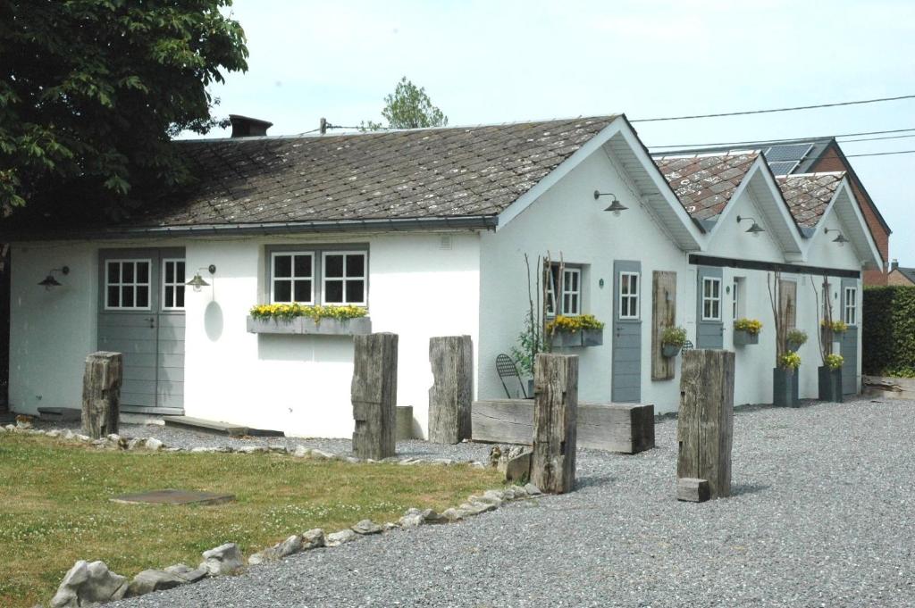 une maison blanche avec des fenêtres et une allée. dans l'établissement Les Chambres du Vivier, chambres d'hôtes et gîte - à 100m -, à Durbuy