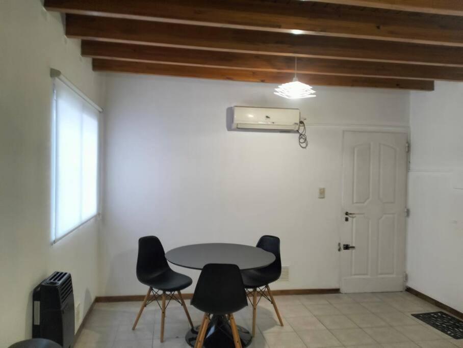 a table and chairs in a room with a door at Cómodo Departamento 2 Ambientes in Guaymallen