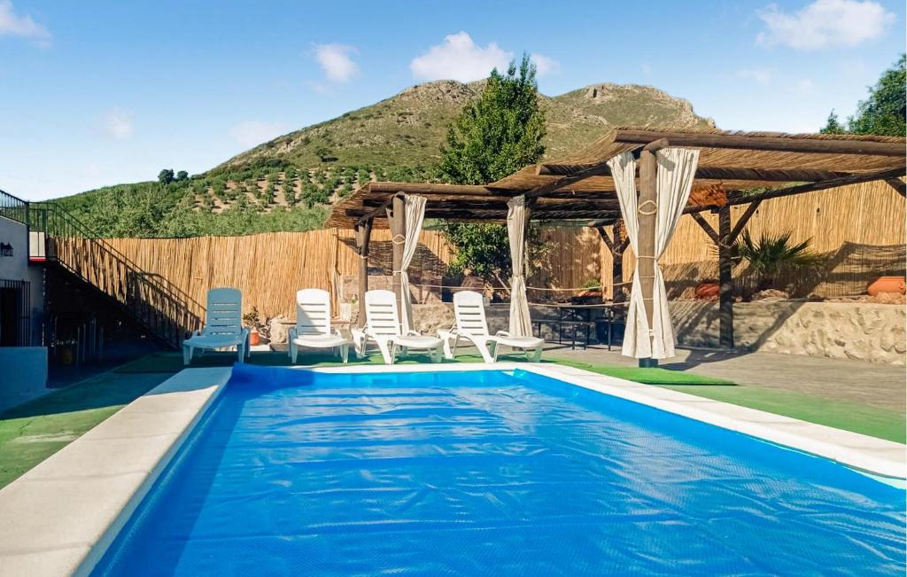 a swimming pool with chairs and a gazebo at Beautiful Home In Priego De Cordoba in Priego de Córdoba