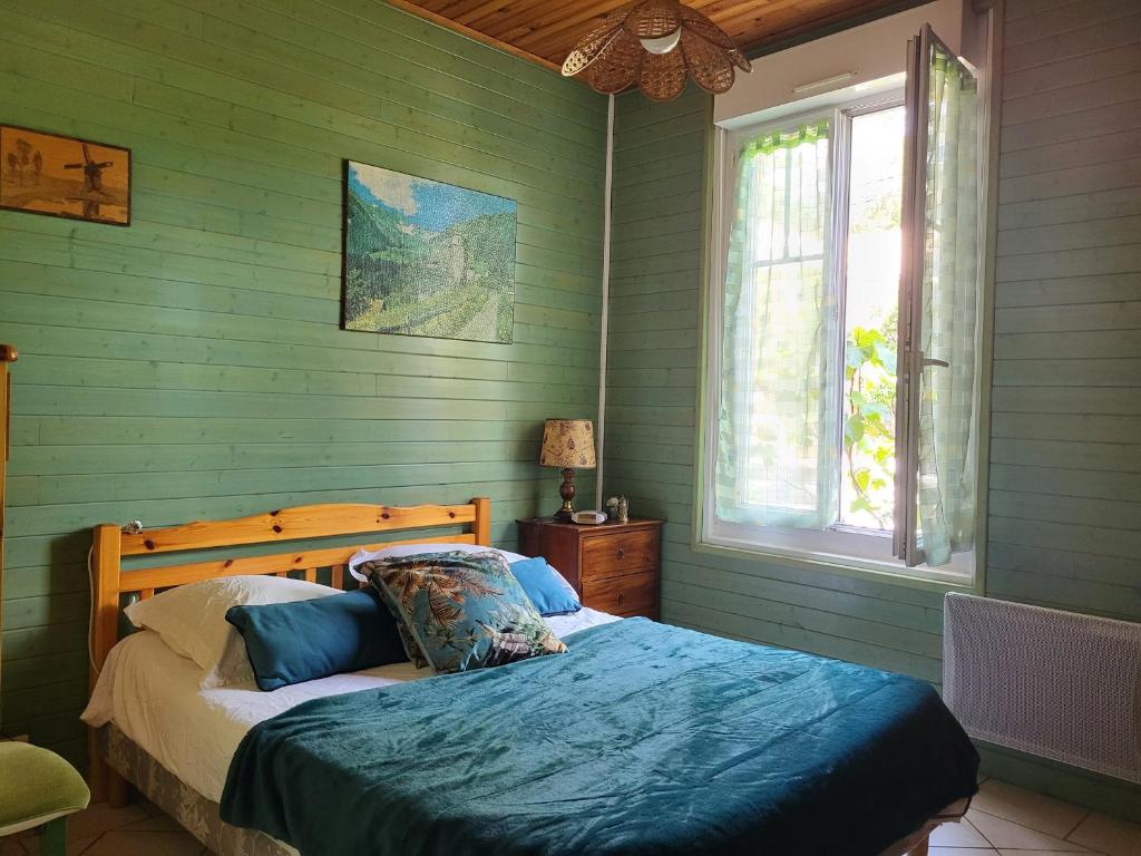 une chambre avec un lit aux murs verts et une fenêtre dans l'établissement Charmante villa à 500m de la plage, calme et tout confort - FR-1-364-57, à Saint-Brévin-les-Pins