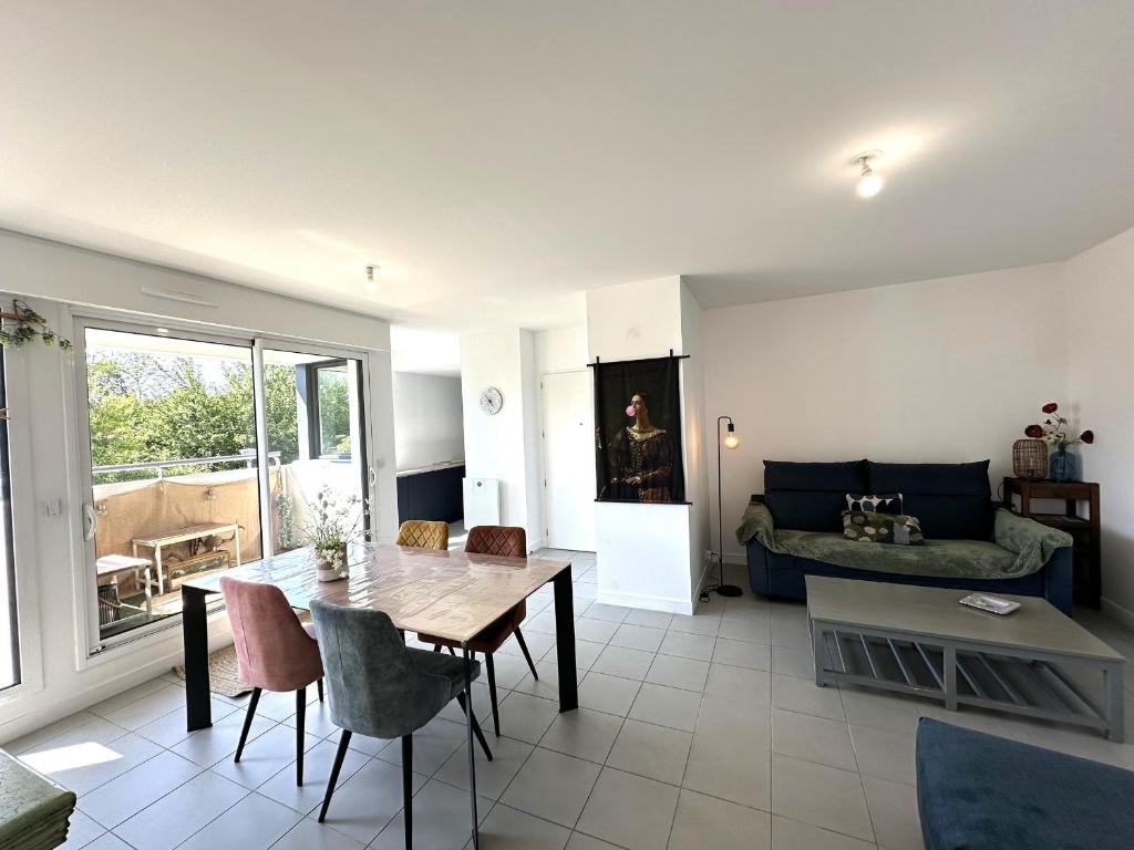 un salon avec une table et un canapé dans l'établissement Élégant appartement à Fouras: proche centre-ville et plage avec terrasse et balcon - FR-1-709-73, à Fouras