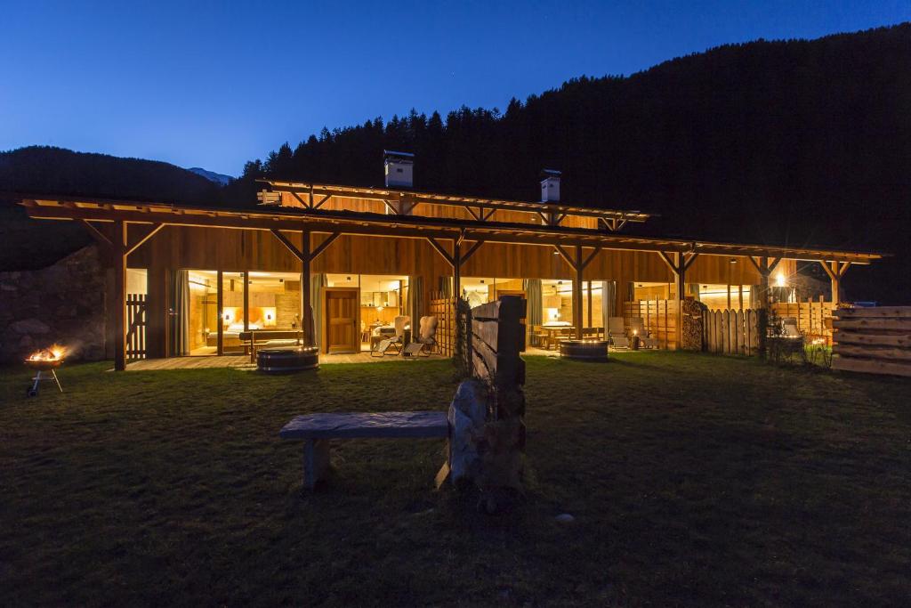ein Gebäude mit einer Bank in der Nacht davor in der Unterkunft Chalet Wiesenglück in Gsieser Tal