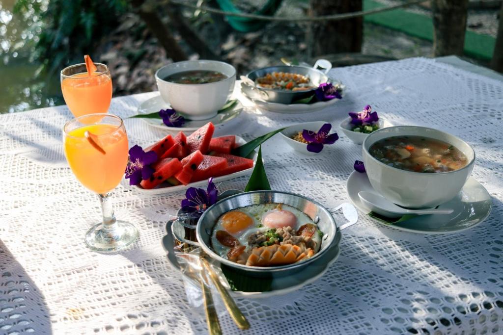 una mesa cubierta con tazones de comida y bebida en Baan Siri, en Ban Dong Bang
