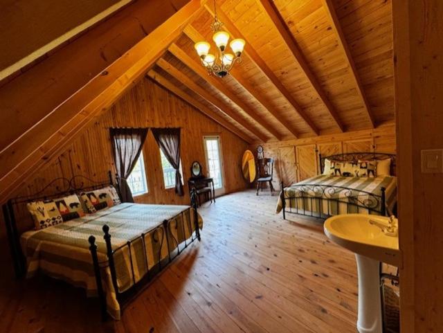 a bedroom with two beds in a wooden cabin at Le Chadou in Tadoussac