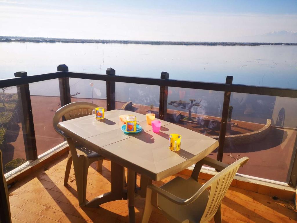une table sur un balcon avec vue sur l'eau dans l'établissement Appartement T2 avec Mezzanine, Piscine et Parking à 1.5 km des plages - FR-1-195-110, au Barcarès