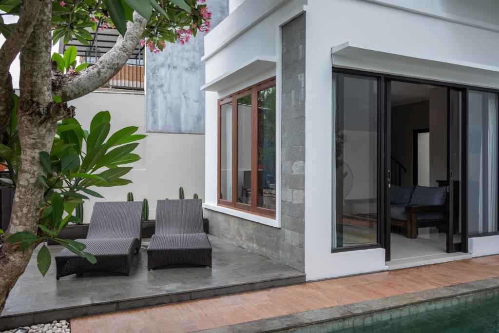 a group of chairs sitting on a patio next to a house at Terrace Mumbul in Nusa Dua