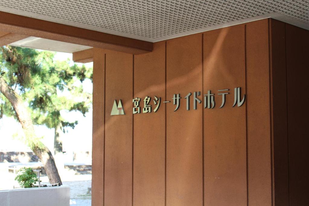 a close up of a wooden door with writing on it at Miyajima Seaside Hotel in Miyajima