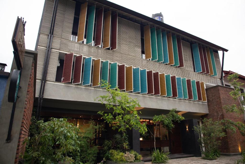 a building with colorful shutters on the side of it at Lake Avenue Hotel Kandy in Kandy