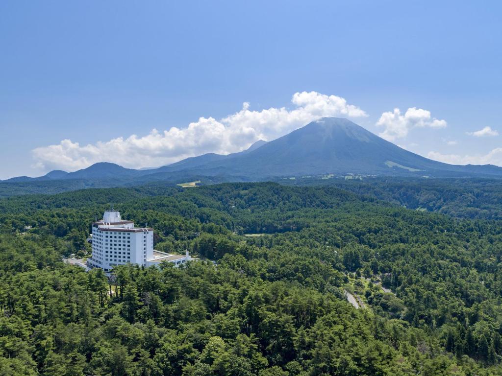 大山的住宿－Mercure Tottori Daisen Resort & Spa，树上的建筑,背景是山