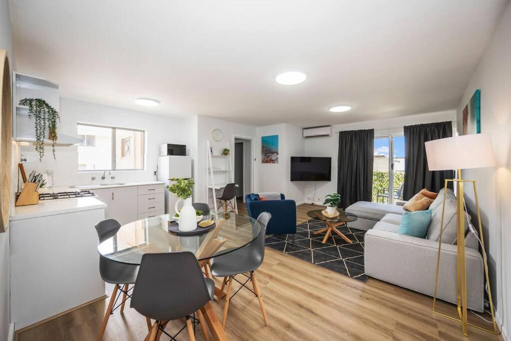 Una cocina y una sala de estar con mesa y sillas. en Apartment 8 Burswood, en Perth
