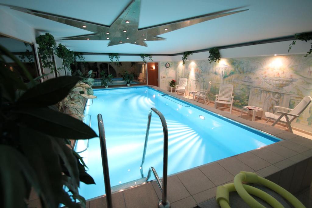 a large swimming pool in a building with at Hotel Im Schwedischen Hof in Binz