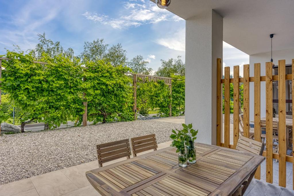 einen Holztisch und Stühle auf einer Terrasse in der Unterkunft VILA LISJAK - Apartments in Podčetrtek
