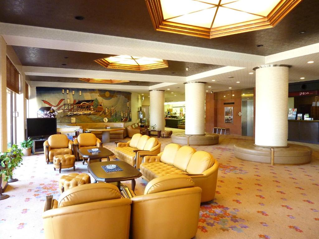 a lobby with couches and chairs in a hotel at Miyajima Seaside Hotel in Miyajima