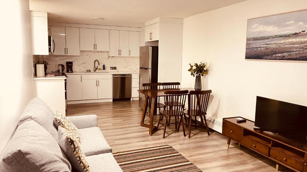 un salon avec un canapé et une table et une cuisine dans l'établissement #304 Mountain View 1BR in Canmore DT, à Canmore