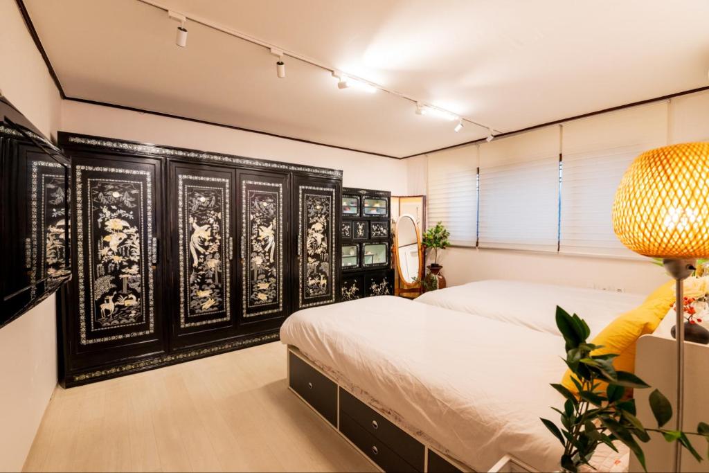 - une chambre avec un lit et un mobilier noir et blanc dans l'établissement Stay Seoul Station, à Séoul