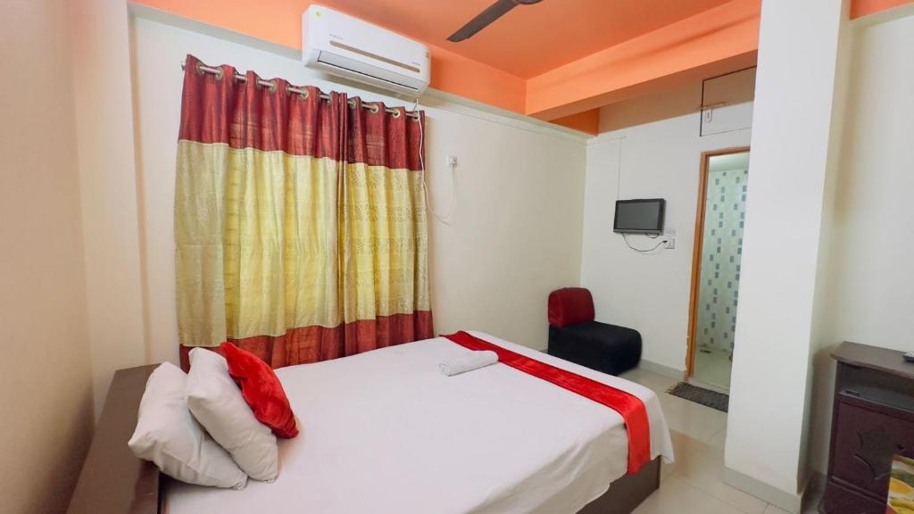 1 dormitorio con 1 cama con cortina y TV en Hotel The Sylhet International, en Dhaka