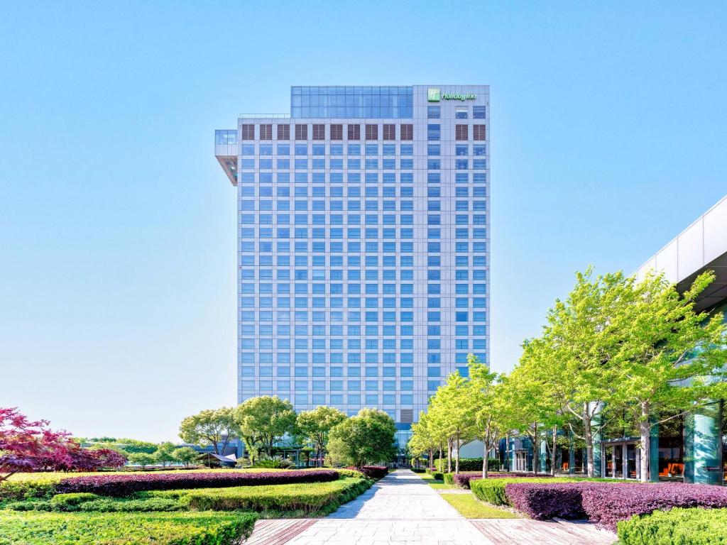 a tall building with a walkway in front of it at Holiday Inn Shanghai Pudong Kangqiao, an IHG Hotel in Shanghai