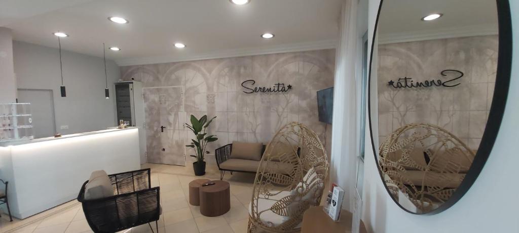 una habitación con sillas de mimbre y una pared con palabras. en B&B Hotel Serenità, en Bellaria-Igea Marina