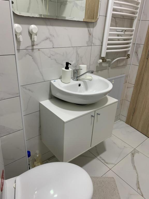 a white bathroom with a sink and a toilet at Apartman-Stefanovic in Vranje