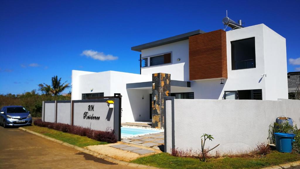 a white house with a fence in front of it at BM Residence in Grand-Baie