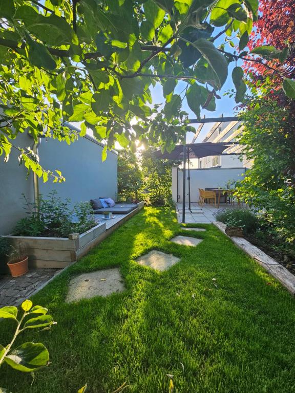 d'un jardin avec de la pelouse verdoyante et d'une terrasse. dans l'établissement ElbQuartier Apartments Magdeburg 'Die Stadtoase', à Magdebourg