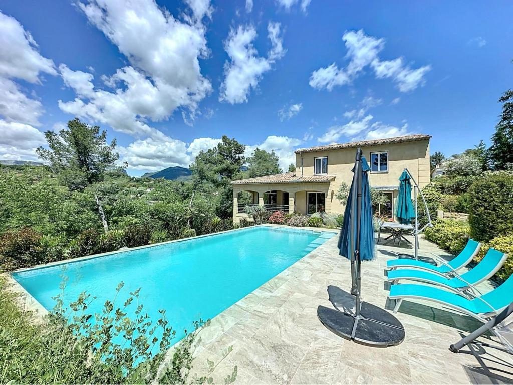 une piscine avec deux chaises et un parasol dans l'établissement VillaNorah, à Le Rouret