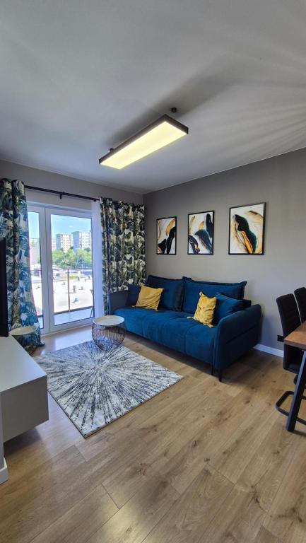 a living room with a blue couch and a table at Sweet Home Grabieniec Apartment in Łódź
