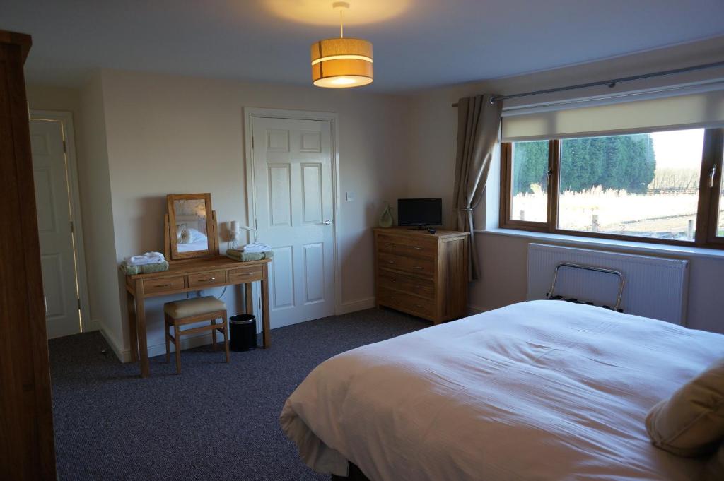 1 dormitorio con cama, escritorio y ventana en Forest View Holiday Park, en Burscough