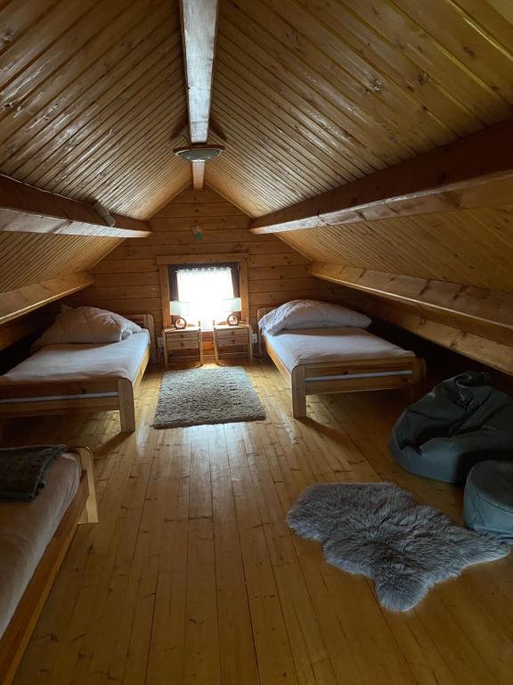 a attic room with two beds and a window at Domki Mizerna - Czorsztyn - Pieniny in Mizerna