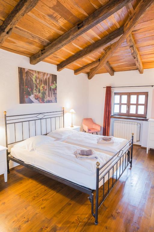 duże łóżko w pokoju z drewnianym sufitem w obiekcie Villa Jurinea in Istrien mit Pool w mieście Barat
