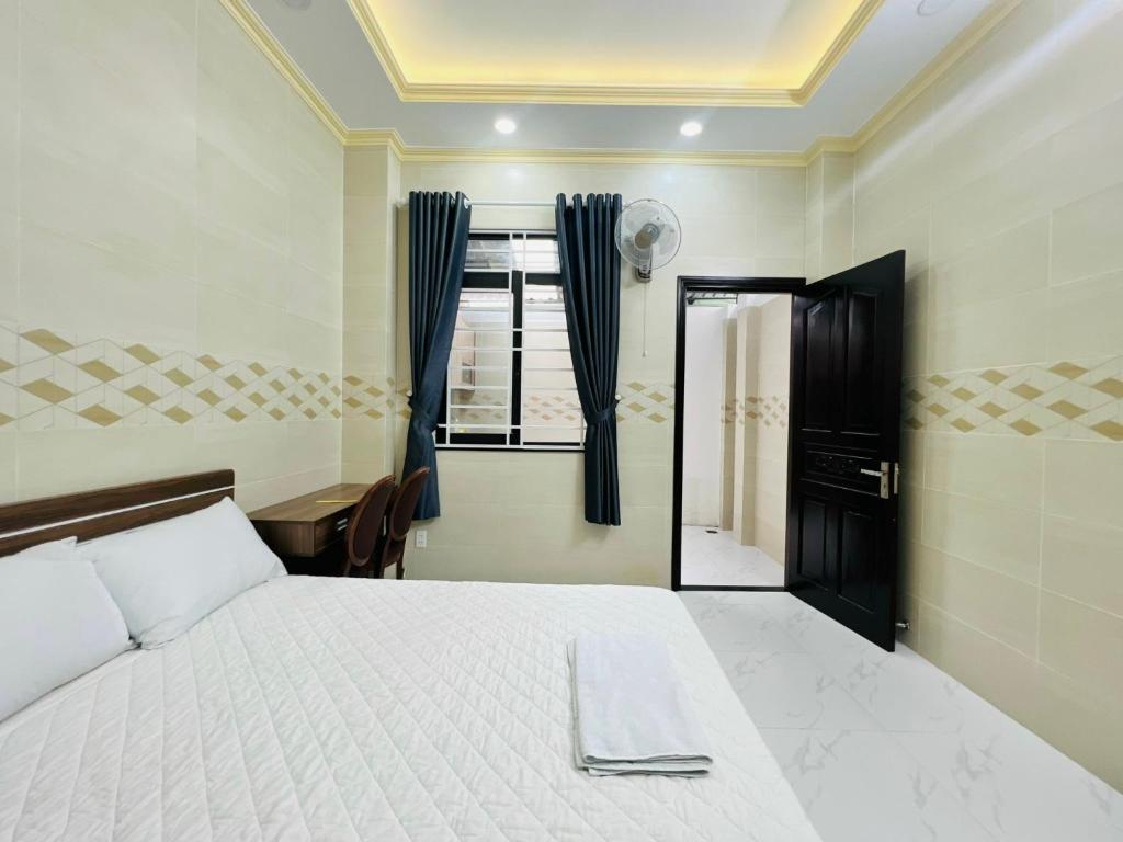 um quarto com uma cama branca e uma janela em DREAM HOUSE em Ho Chi Minh