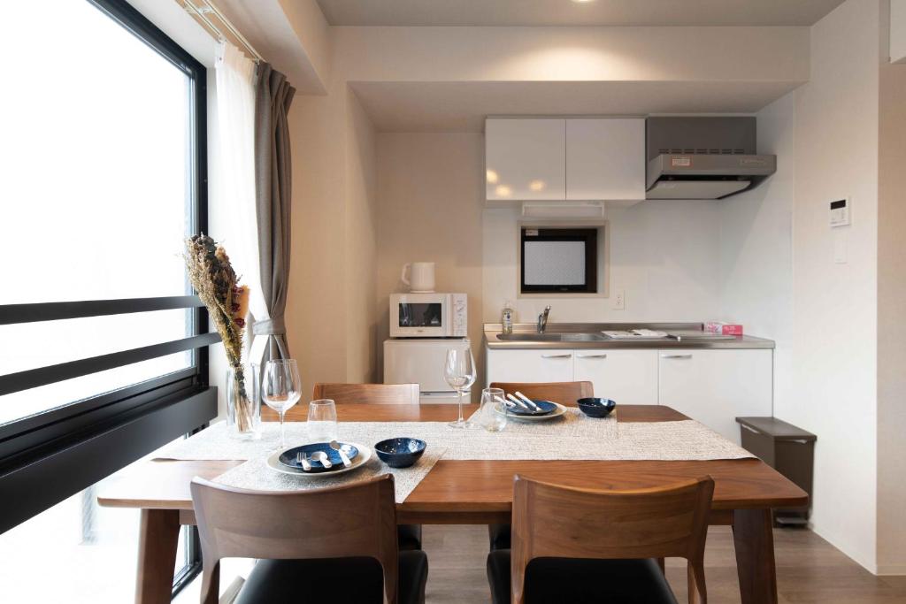 een keuken met een houten tafel en stoelen en een eetkamer bij Regale Dotonbori East in Osaka