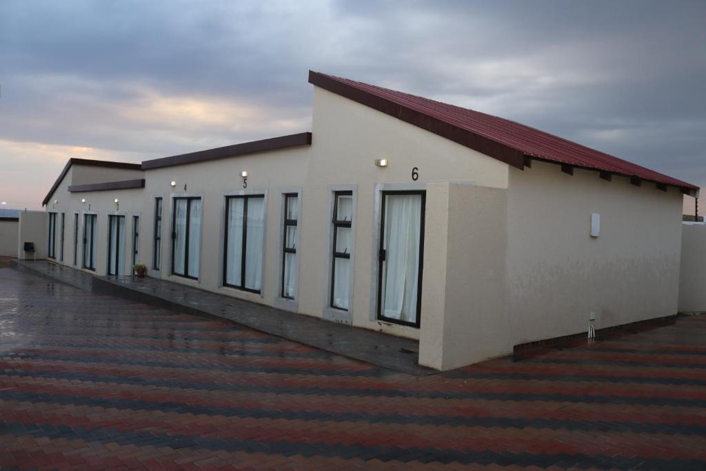 un gran edificio blanco con techo rojo en Lesiba guesthouse, en Kwamhlanga