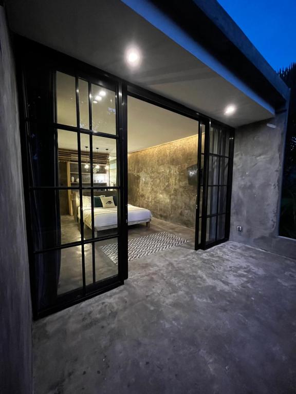 een slaapkamer met uitzicht op een bed door glazen deuren bij The CIVYT in Ubud