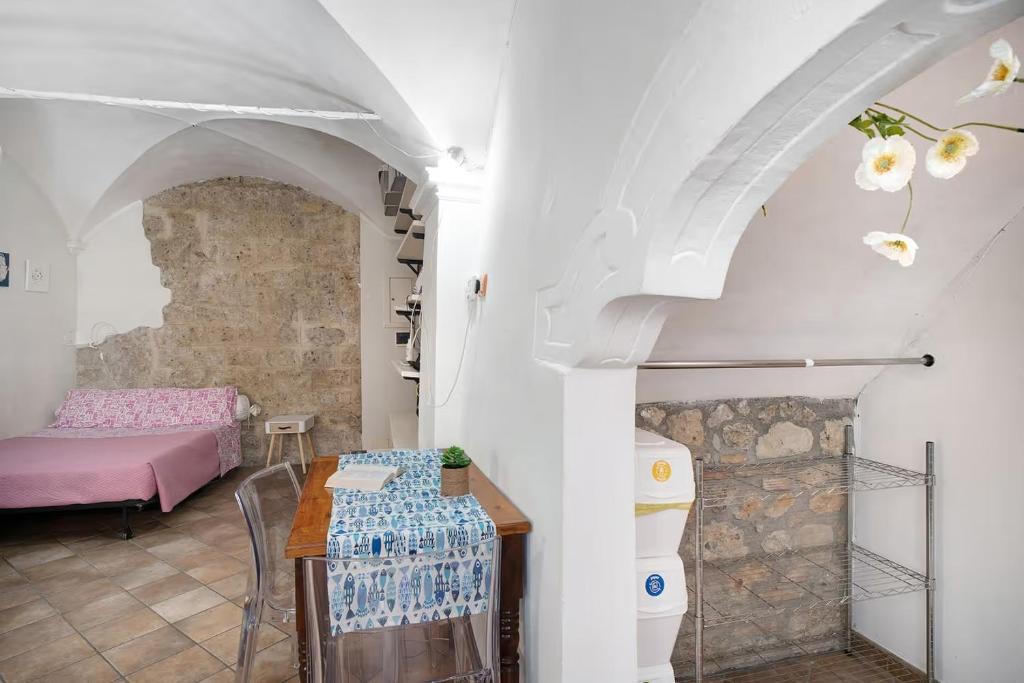 a living room with a table and a bed at Le Trifore in Ventimiglia