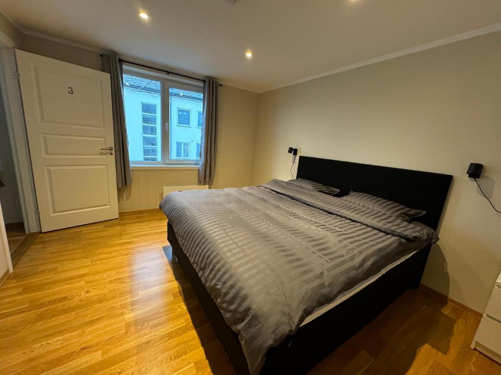 a bedroom with a bed and a large window at Charming 3-Bedroom Apartment in the Heart of Kristiansund in Kristiansund