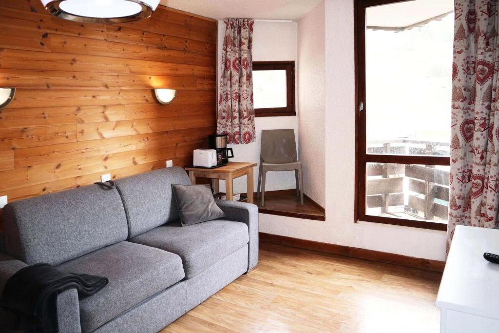 un salon avec un canapé et une fenêtre dans l'établissement Residence Le 1650 - Studio pour 4 personnes cœur de station MAE-8161, aux Orres